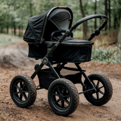 Robust black all-terrain stroller with a bassinet-style seat, large textured wheels, and a sturdy frame, ideal for outdoor paths and rugged trails.