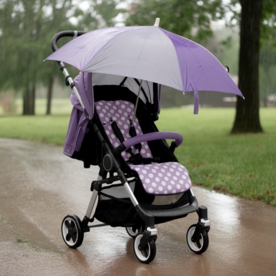 Purple and white polka dot baby stroller with a matching umbrella cover, positioned on a rainy park pathway, providing essential weather protection for infants and toddlers.