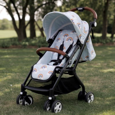 Lightweight travel stroller with a cheerful rainbow-patterned canopy and cushioned seat, perfect for outdoor adventures and park strolls.